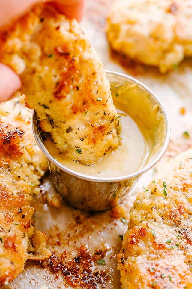 Dipping chicken tenders in honey mustard.