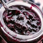 Close up of a jar of homemade blueberry sauce.