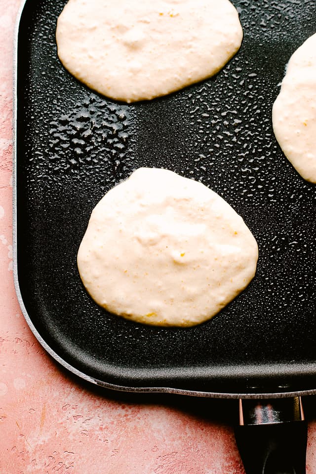 Fluffy pancakes cooking on a griddle
