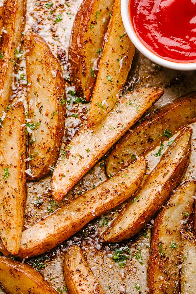Homemade potato wedges with ketchup.