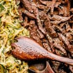 soy glazed flank steak with zoodles in a skillet