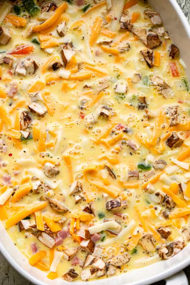 mushrooms, cheese, ham, and eggs in a baking dish
