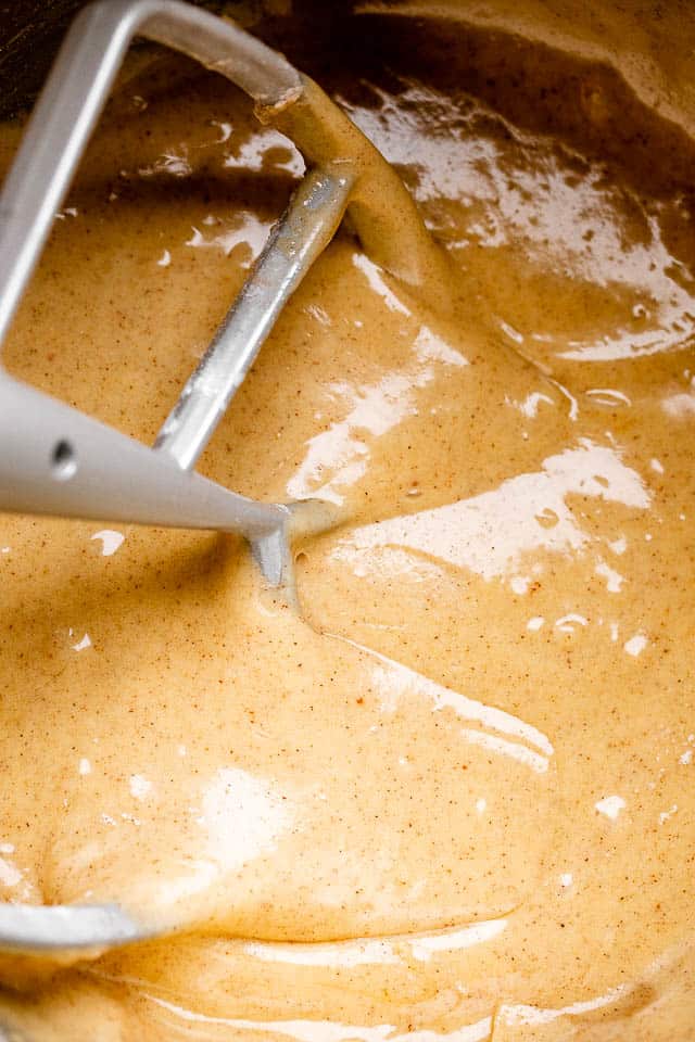 Mixing the batter from a spiced carrot cake recipe with a mixer.