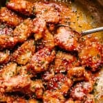 Crispy Honey Sesame Chicken being stirred in a pan