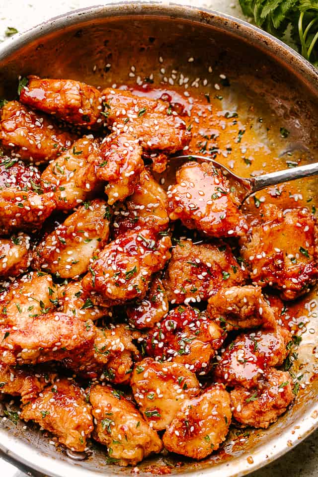 Crispy Honey Sesame Chicken being stirred in a pan
