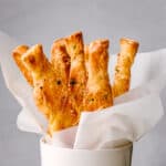 Puff Pastry sticks ready to serve in a white cup.