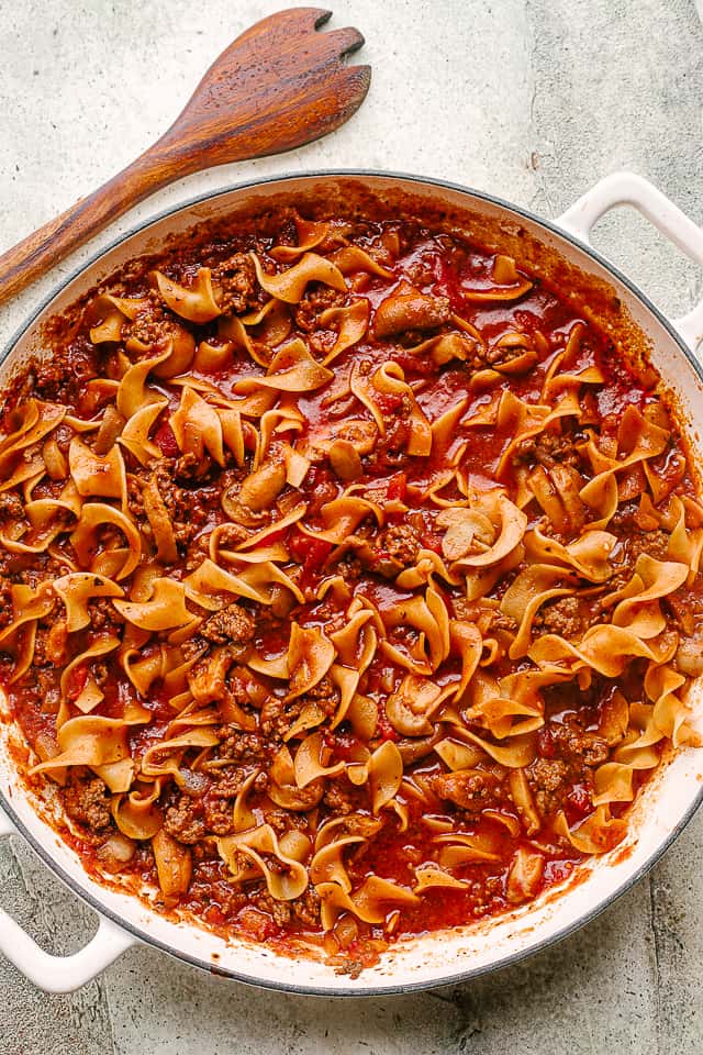 Curly pasta and meat sauce in a skillet.