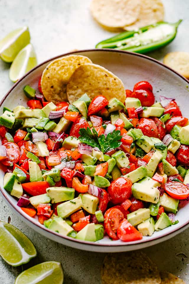 avocado salsa served with tortilla chips and lime wedges