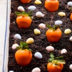 Oreo Dirt Cake topped with chocolate covered strawberries and chocolate egg candy