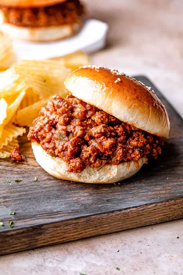 serving sloppy joes in a bun with potato chips on the side