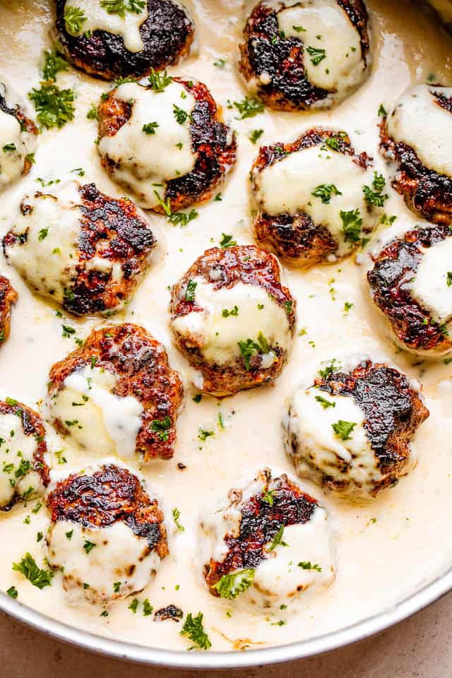 Cooked Swedish meatballs in creamy sauce, garnished with parsley.