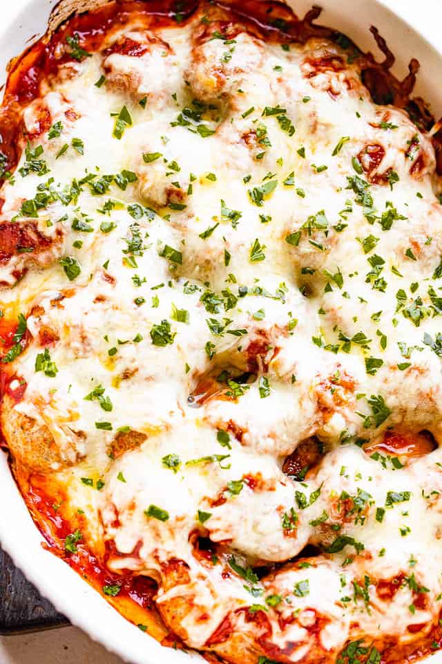 baking dish with melted cheese over meatballs