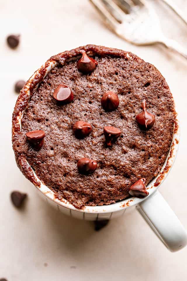 chocolate cake in a mug topped with chocolate chips