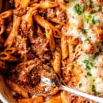 penne pasta casserole with ground beef in a white baking dish