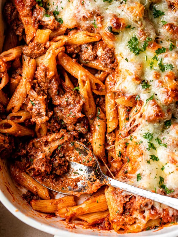 penne pasta casserole with ground beef in a white baking dish