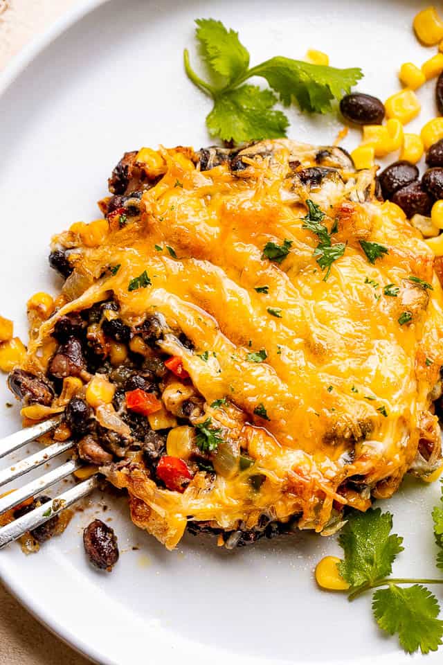 fork next to a mushroom stuffed with corn, black beans, and cheese