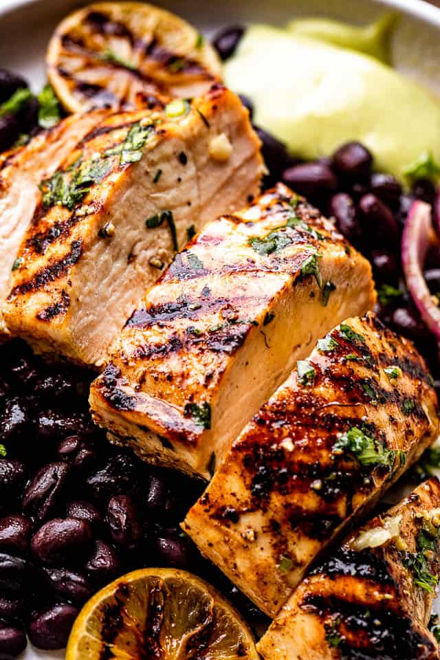 Sliced grilled chicken breast set over black beans