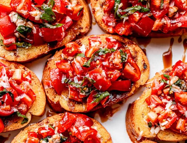 bread slices topped with tomato salad and served on a white platter