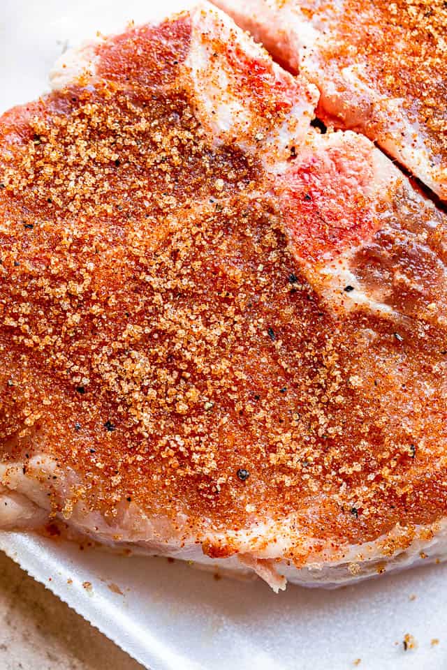 raw pork chops rubbed with a seasoning