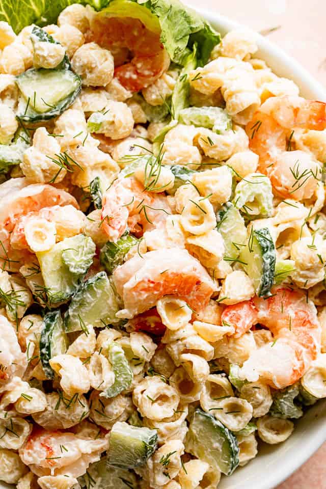 close up top shot of Creamy Shrimp Pasta Salad studded with sliced cucumbers and plump shrimp