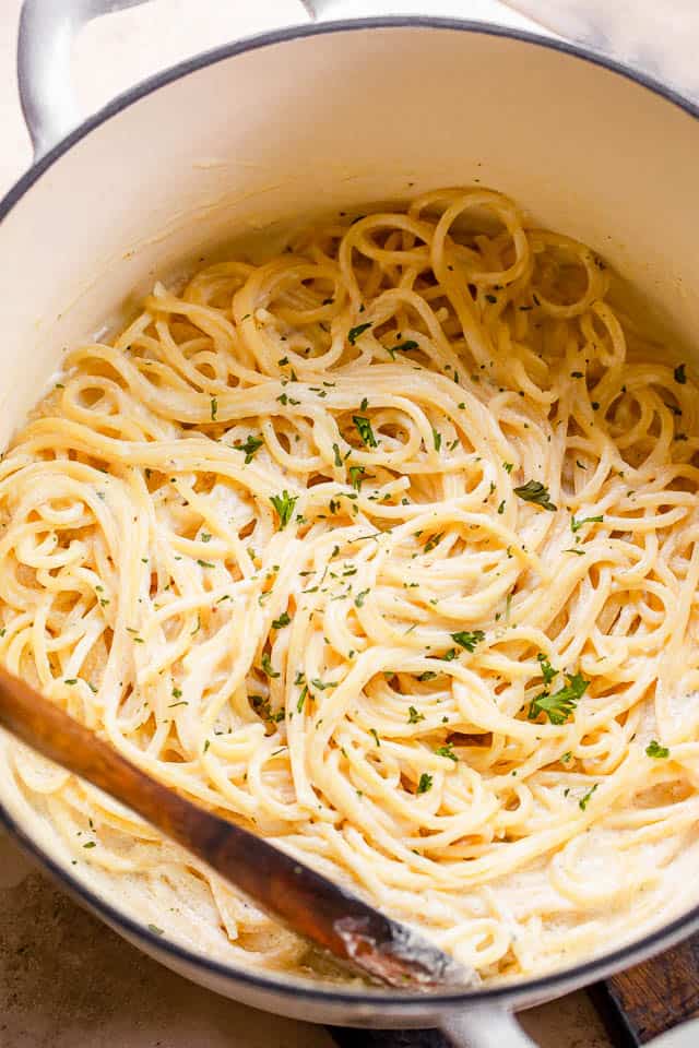 top shot of cream cheese spaghetti in a white pot