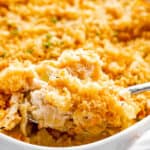 scooping out tuna noodle casserole from baking dish