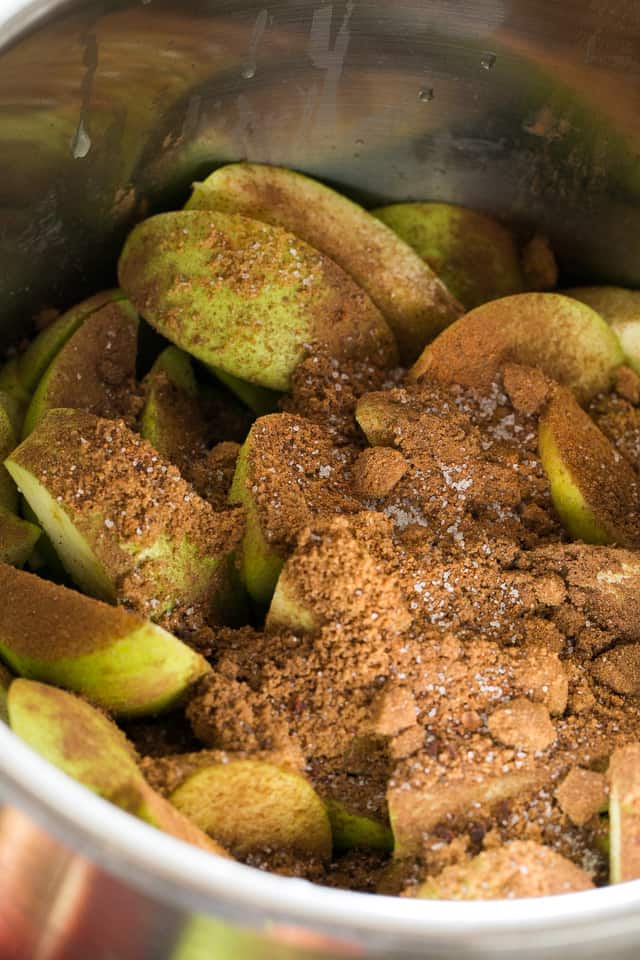 apple wedges in instant pot insert sprinkled with brown sugar and cinnamon