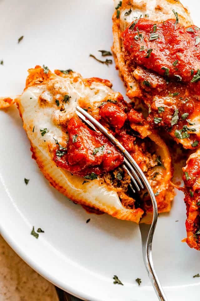 cutting into stuffed pasta shells with a fork