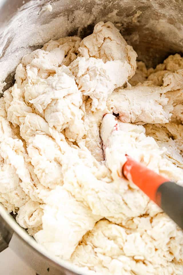 mixing bread dough with a red rubber spatula