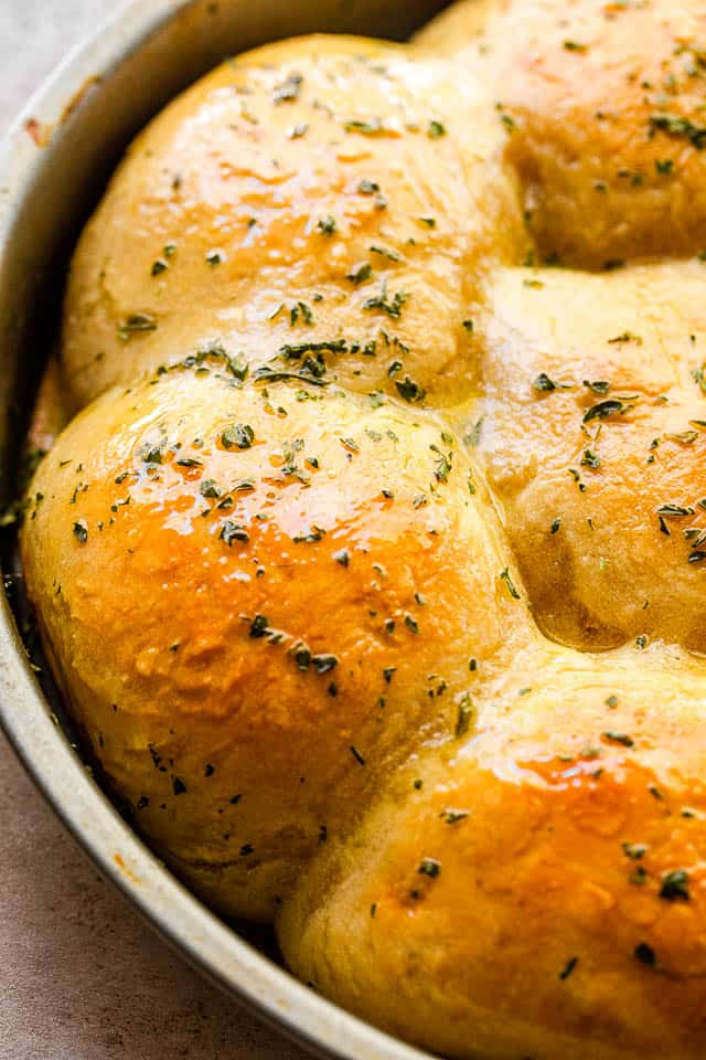 side close up shot of baked dinner rolls garnished with parsley