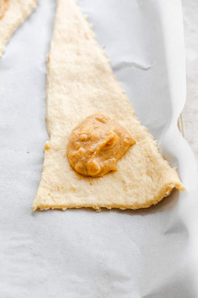 unrolled raw crescent dough with a dollop of pumpkin filling