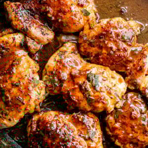 overhead shot of apple cider glazed chicken thighs inside a skillet