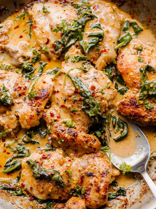 overhead shot of boneless skinless chicken thighs in a creamy sauce with spinach