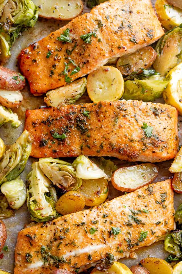 overhead shot of roasted old bay salmon fillets with brussel sprouts and yellow squash