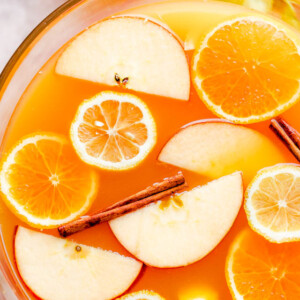 overhead close up shot of apple cider punch in a punch bowl with slices of fruit floating on top