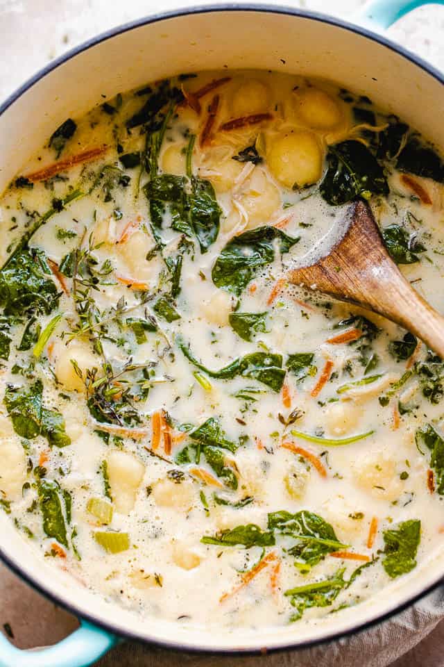 overhead shot of creamy gnocchi soup with spinach and chicken pictured in dutch oven