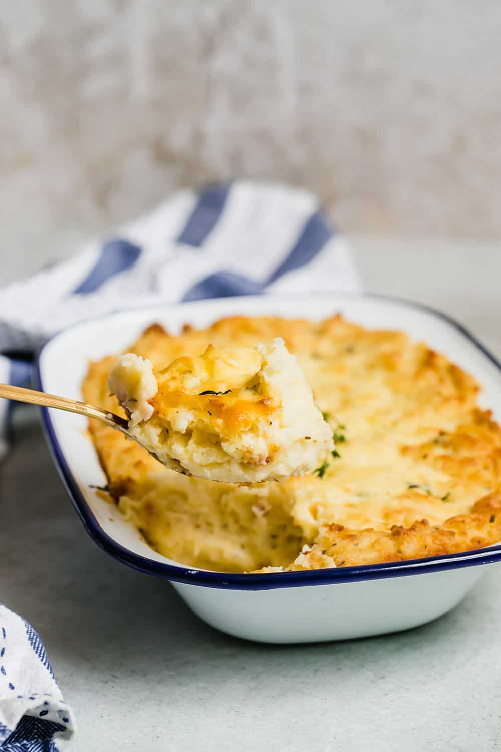 A spoon scooping creamy mashed potatoes out of a dish.