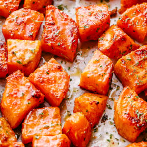 overhead shot of chopped sweet potatoes on parchment paper