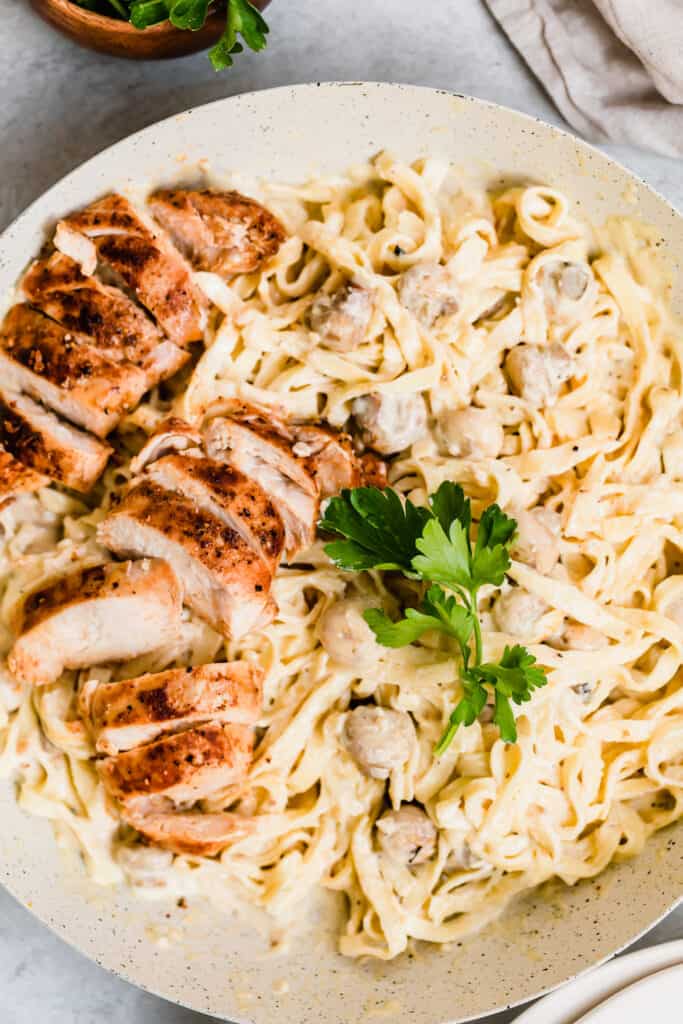 Chicken Fettuccine Alfredo in a Large Bowl, Garnished with Parsley