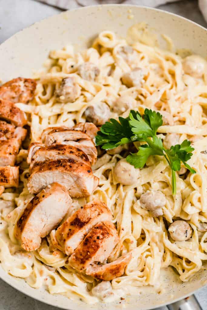 Chopped Chicken and Fresh Parsley over a Bowl of Alfredo Pasta