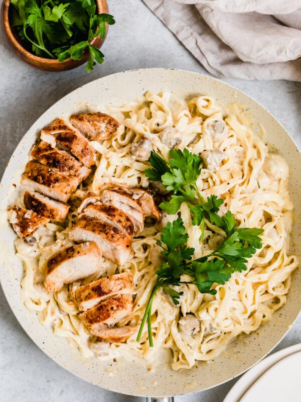 Two Sliced Chicken Breasts Over a Bowl of Creamy Fettuccine Alfredo