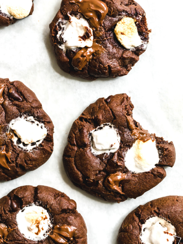 Six Gooey Chocolate and Marshmallow Sugar Cookies Arranged on Top of Parchment Paper