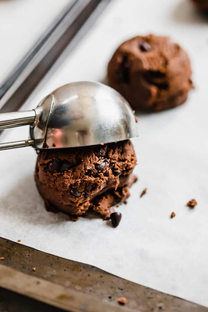A Metal Ice Cream Scoop Releasing a Ball of Chocolate Sugar Cookie Dough