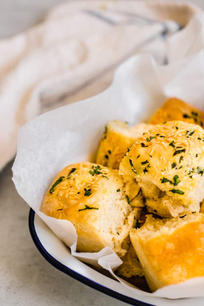 Parmesan Dinner Rolls Inside of a Serving Dish in Front of a White Towel