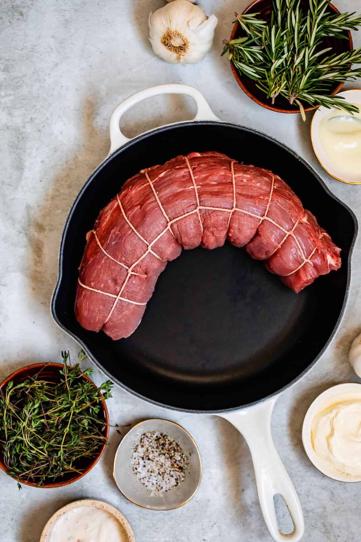A Tied Beef Tenderloin in a Skillet Next to the Other Recipe Ingredients
