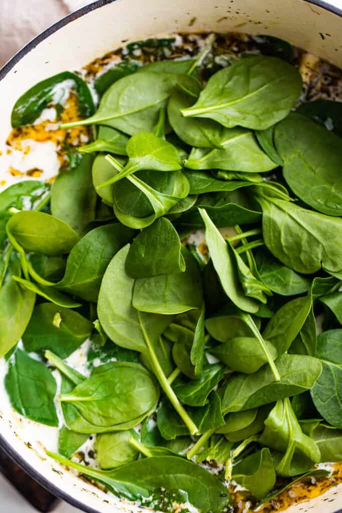 cooking baby spinach leaves in a soup