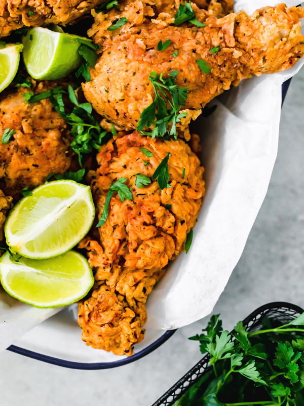 A Basked of Buttermilk Fried Chicken with Lime Wedges Inside
