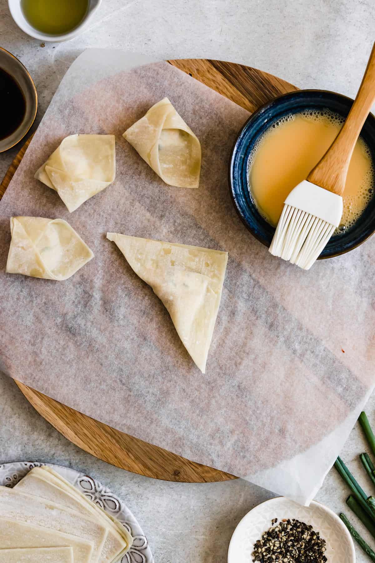 Filled wonton wrappers being shaped.
