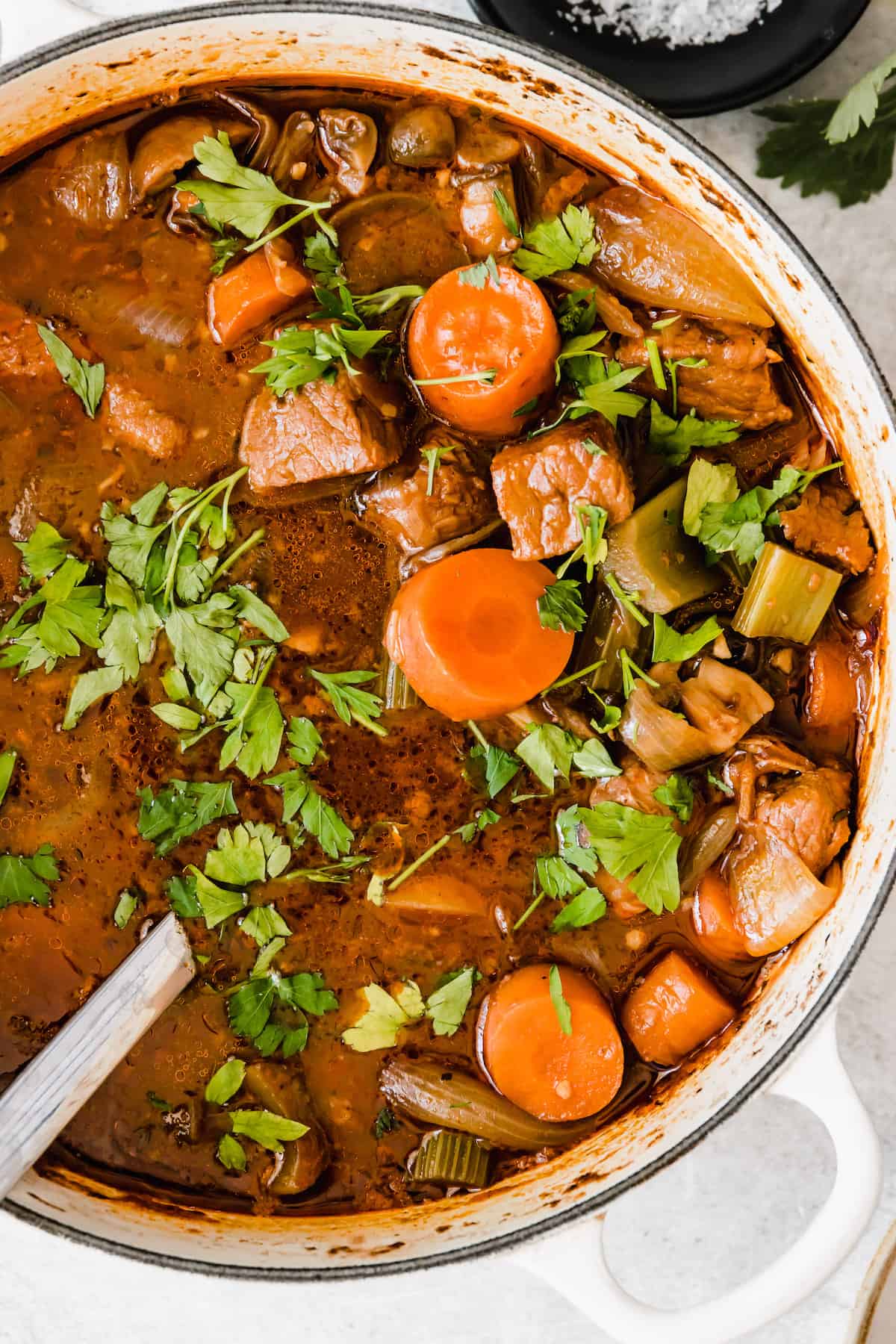 overhead close up shot of beef stew in a white dutch oven