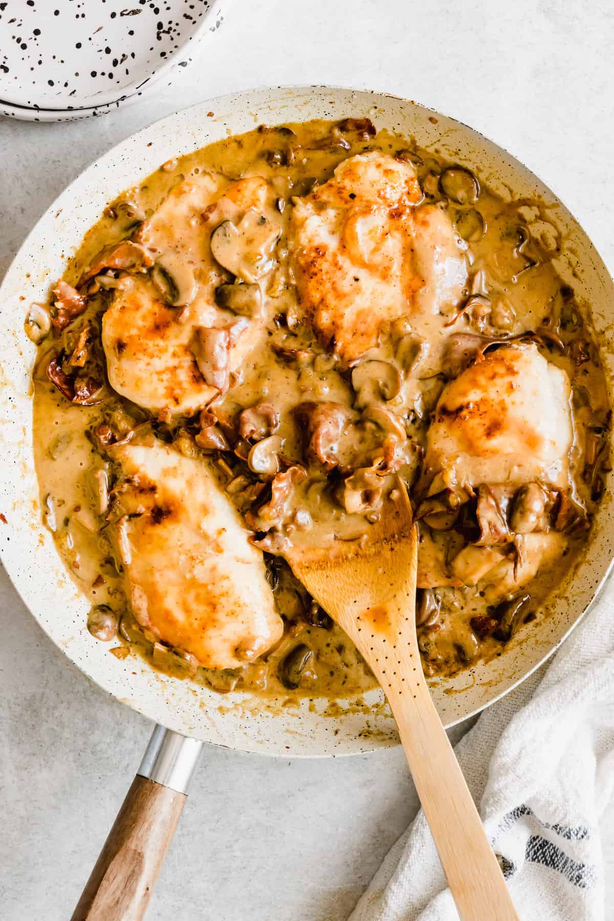 Four pieces of chicken in a mushroom marsala sauce.